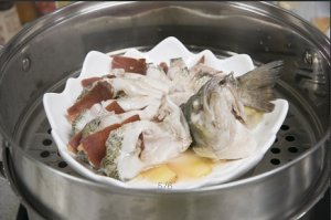 将鲈鱼成花状摆好，将火腿切片放入各缝隙中，放入锅中隔水蒸12分钟拿出，撒上葱花即可。。