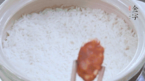 煮开后转小火，，，当米饭出现小孔时，，，铺上金字麻辣香肠！！！